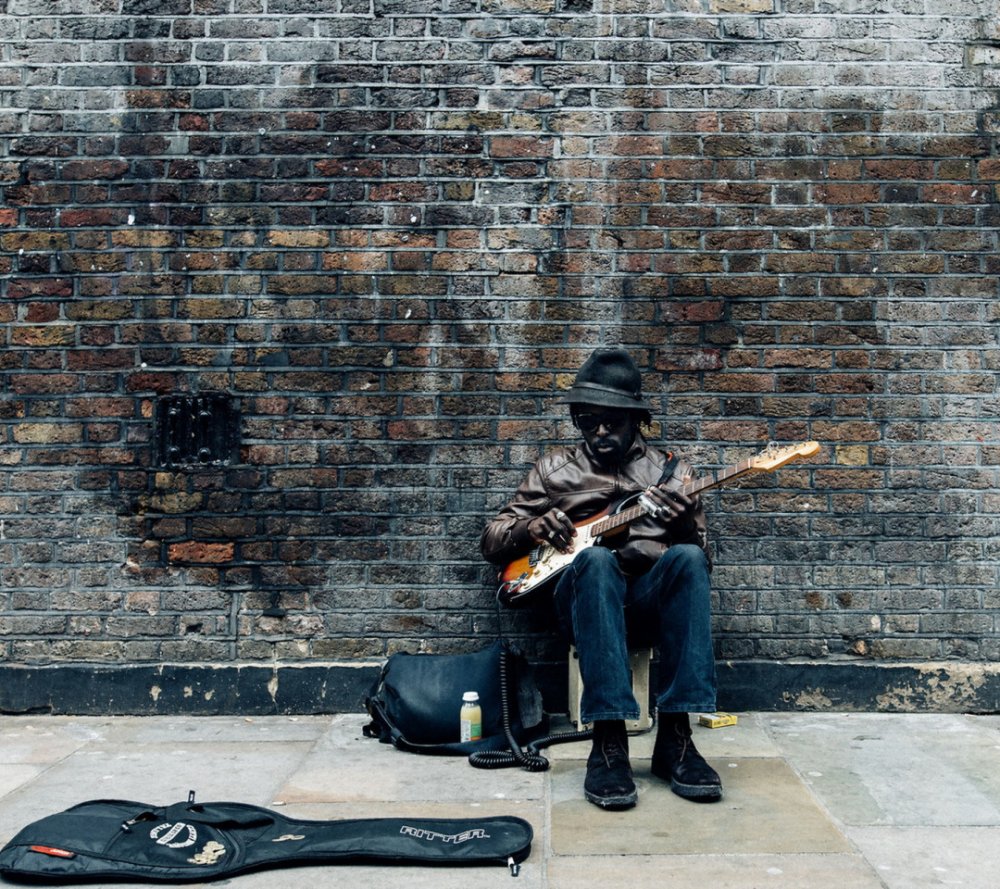 Гитарист на фоне кирпичной стены