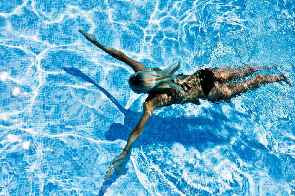 Женщина плывет в бассейне