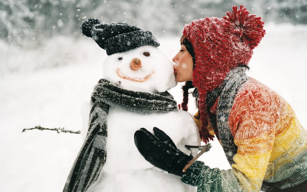 Девушка целует снеговика