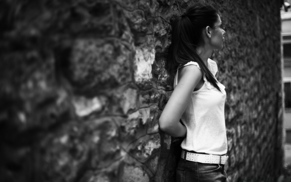 Девушка у каменной стены