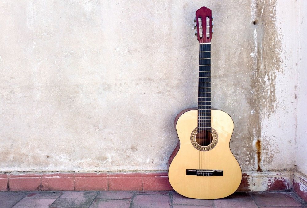 Гитара классическая на фоне стены