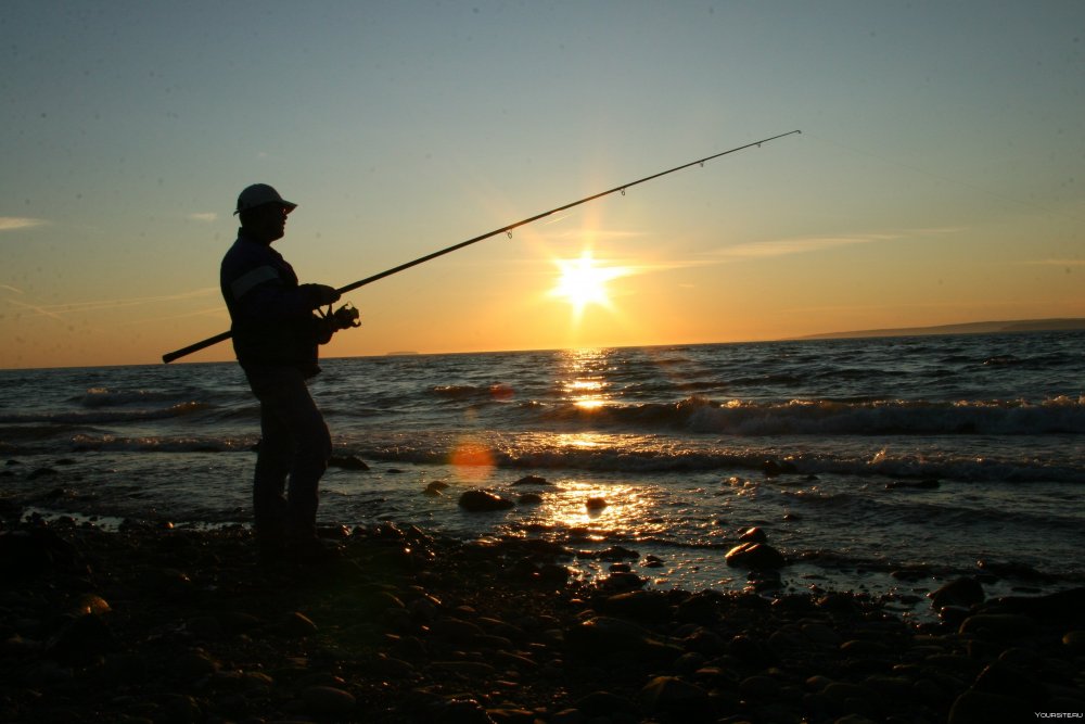 Рыбак на берегу с удочкой