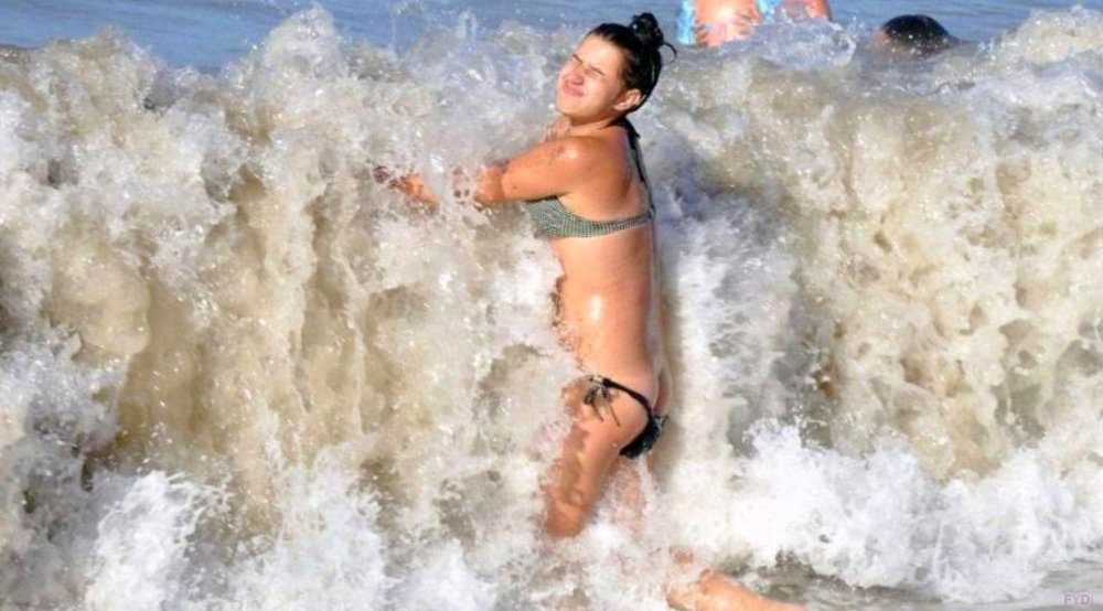 Девушка купается в волнах