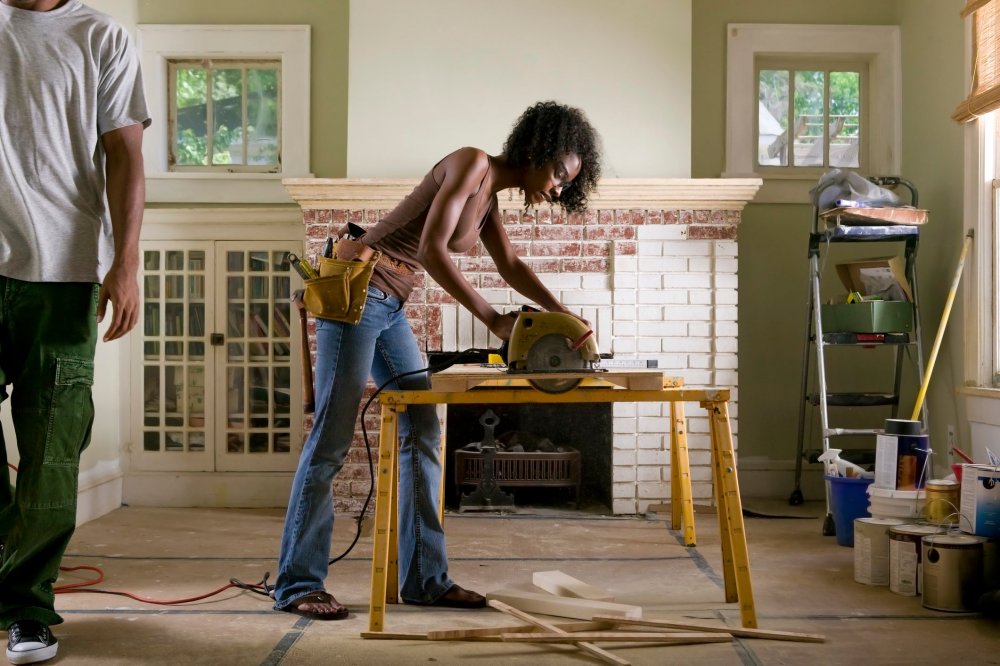 Женщина ремонтирует дом