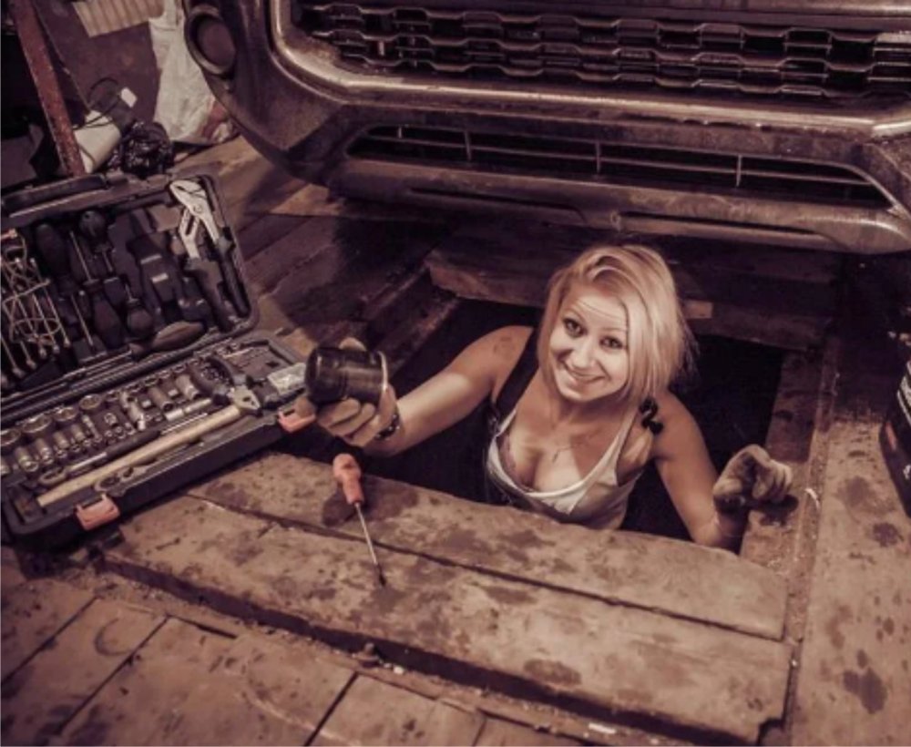 Женщина чинит машину