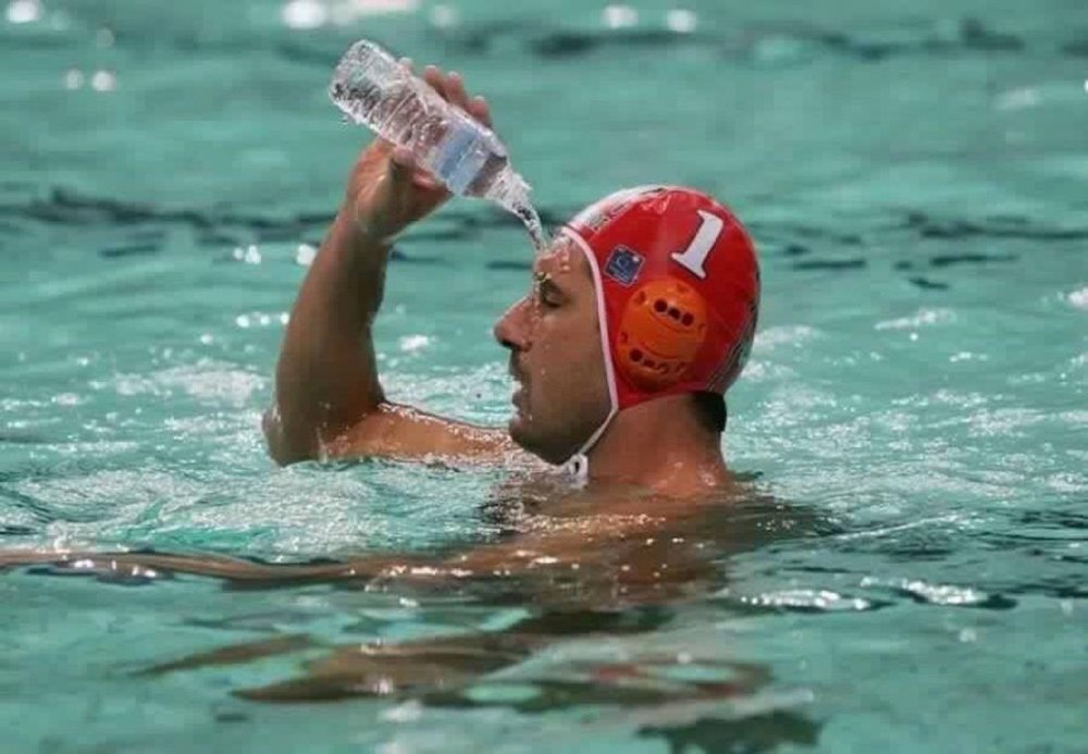 Пловец пьет воду в бассейне