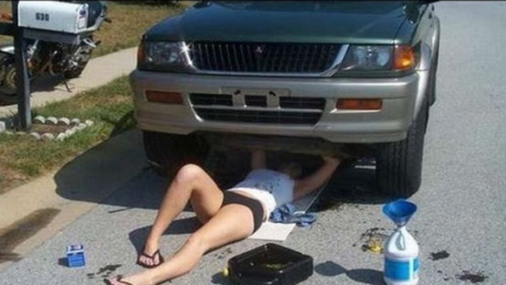 Девушка под машиной ремонтирует
