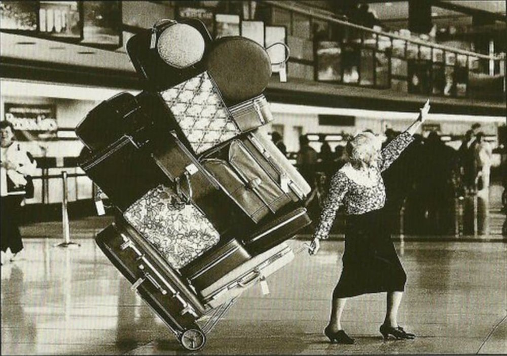 Женщина тащит чемодан