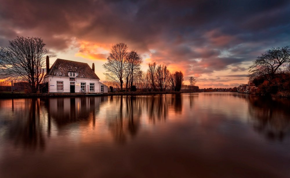 Дом у реки с закатом