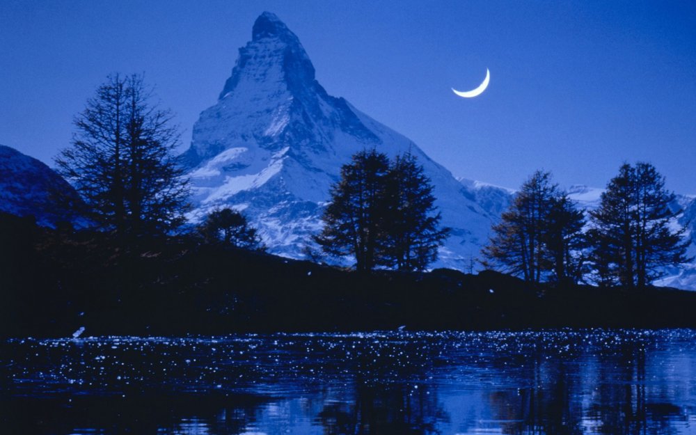 Гора Маттерхорн в Швейцарии и озеро ночью