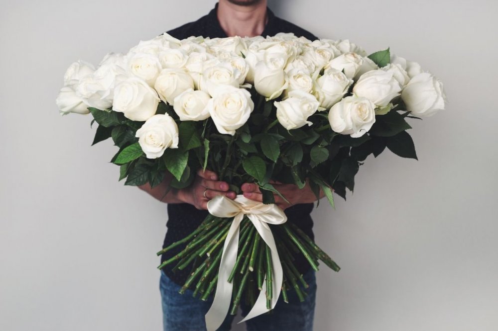 Мужчина с букетом белых роз